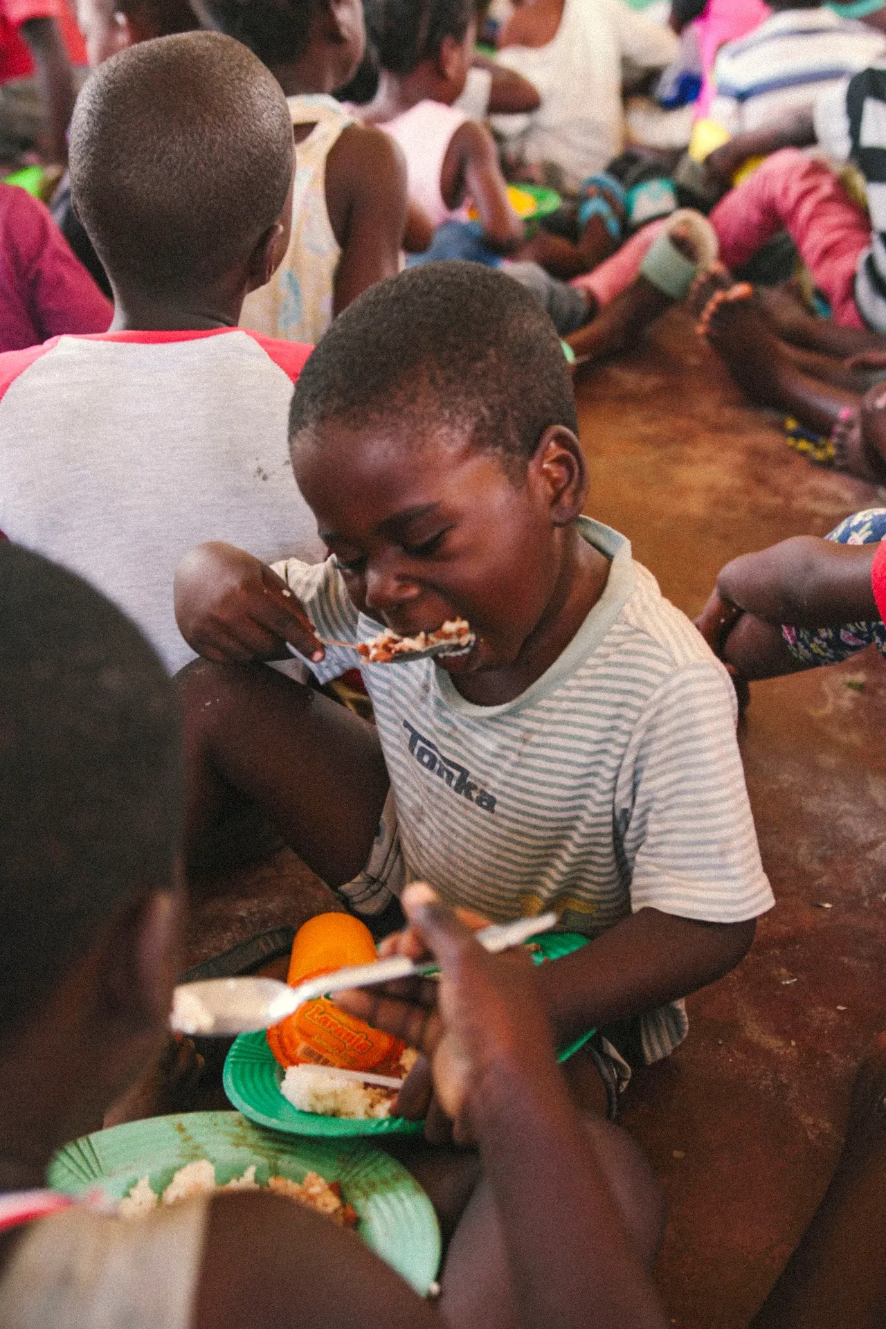 Children eating together on the ground