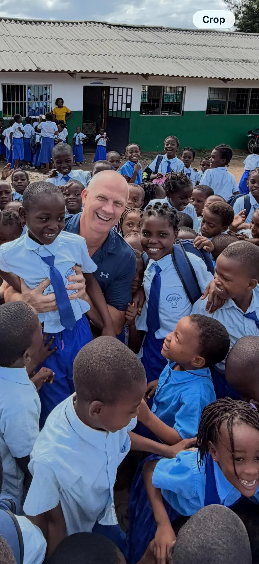 Children in school uniforms welcoming visitors