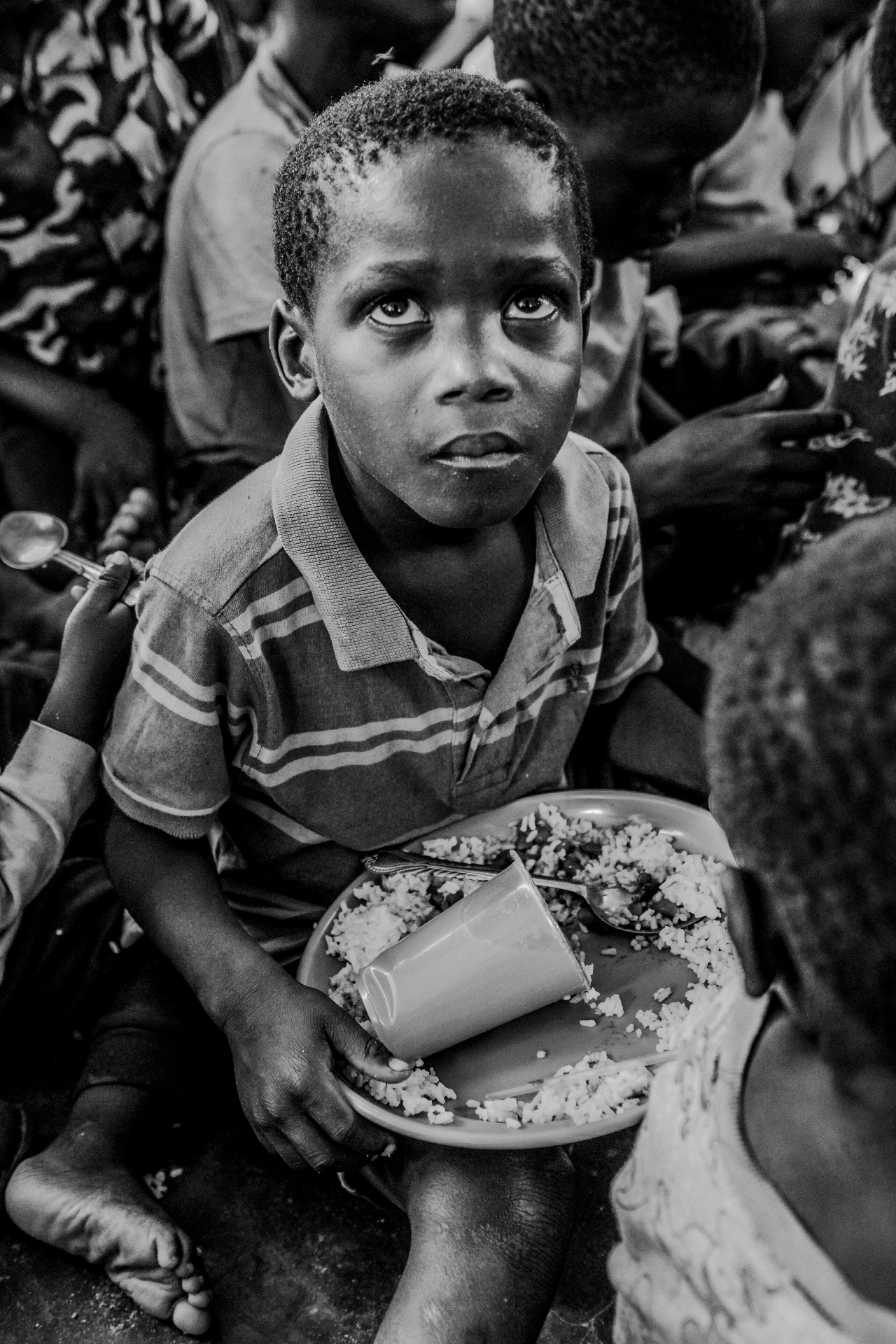 Boy in Mozambique holding a plate of rice